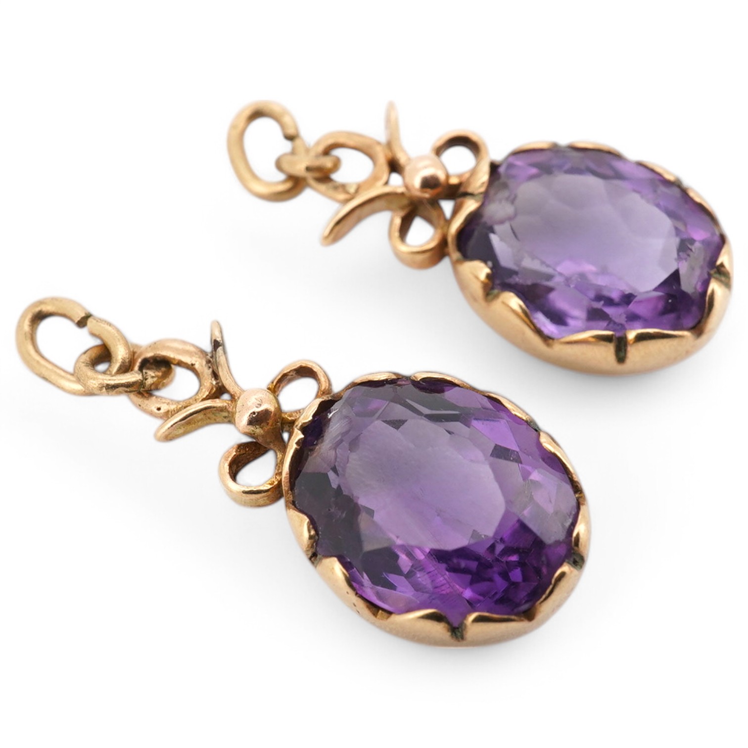 A pair of yellow metal and oval cut amethyst set drop earrings, lacking fittings, overall 28mm. Condition - poor to fair